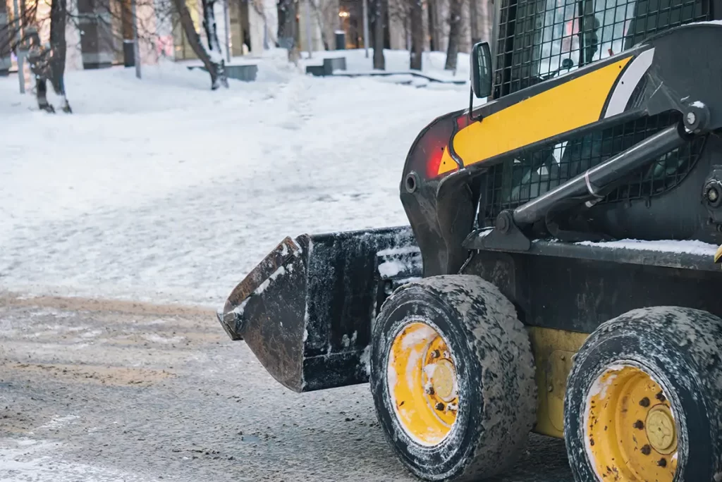 Snow removal specialist using a snowblower on a commercial corporate property