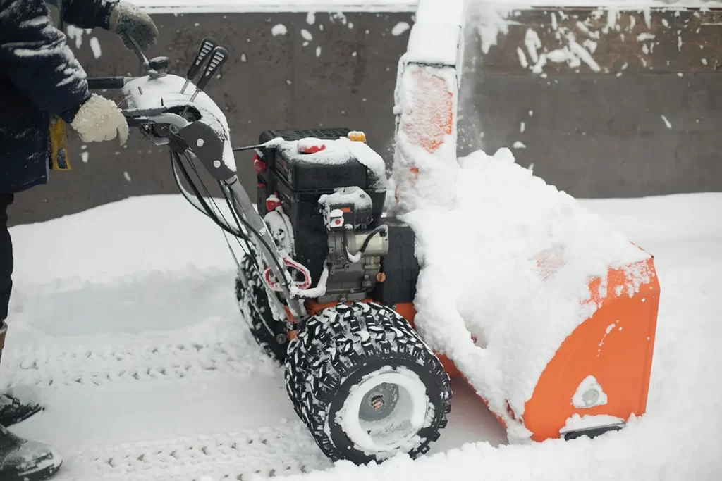 Technician spreading deicing material on icy sidewalks
