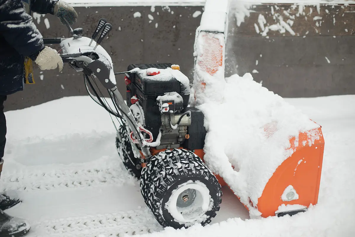 Technician spreading deicing material on icy sidewalks